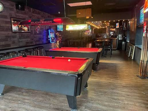 Interior of Drifters Saloon with pool tables, bar seating, and game-day screens