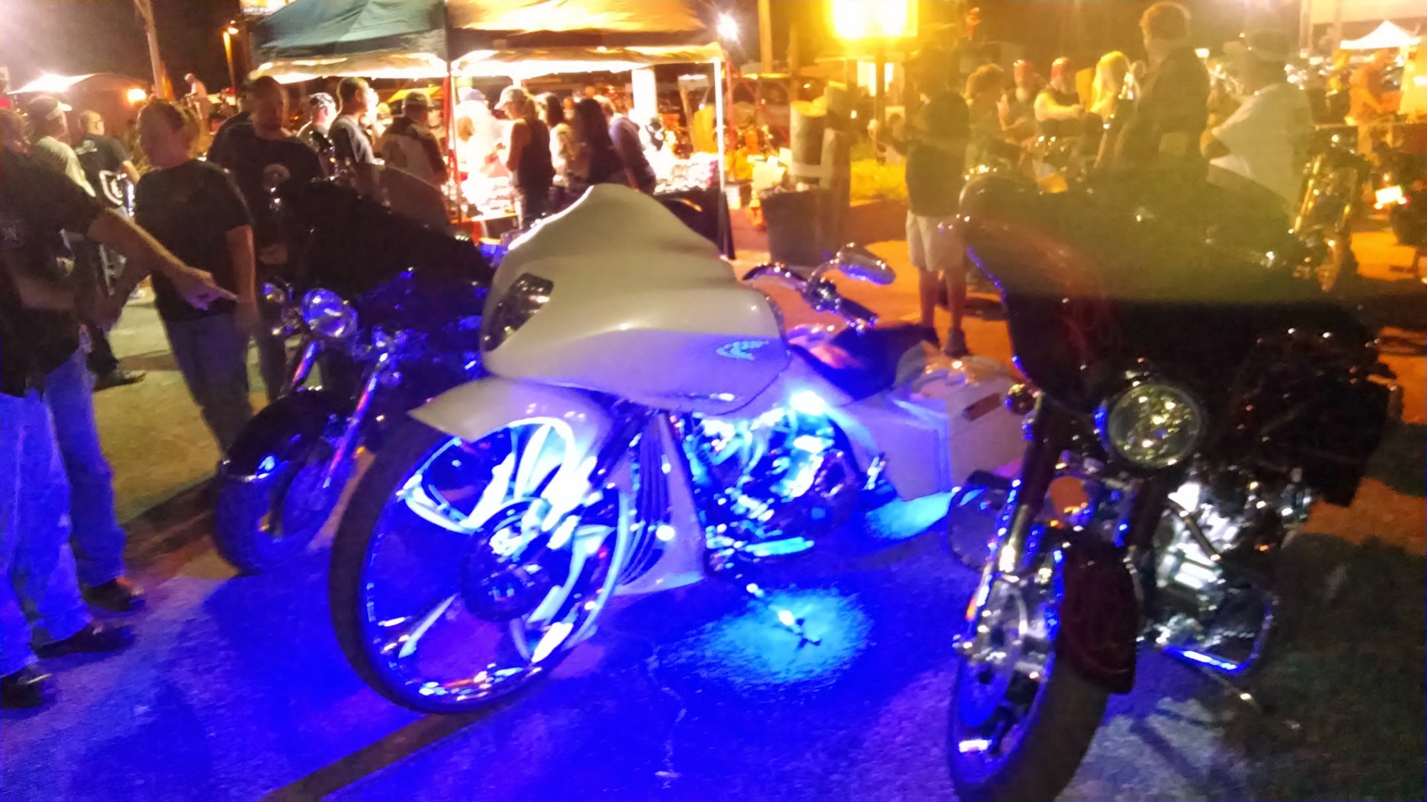 Motorcycles with LED lights at a rally at night