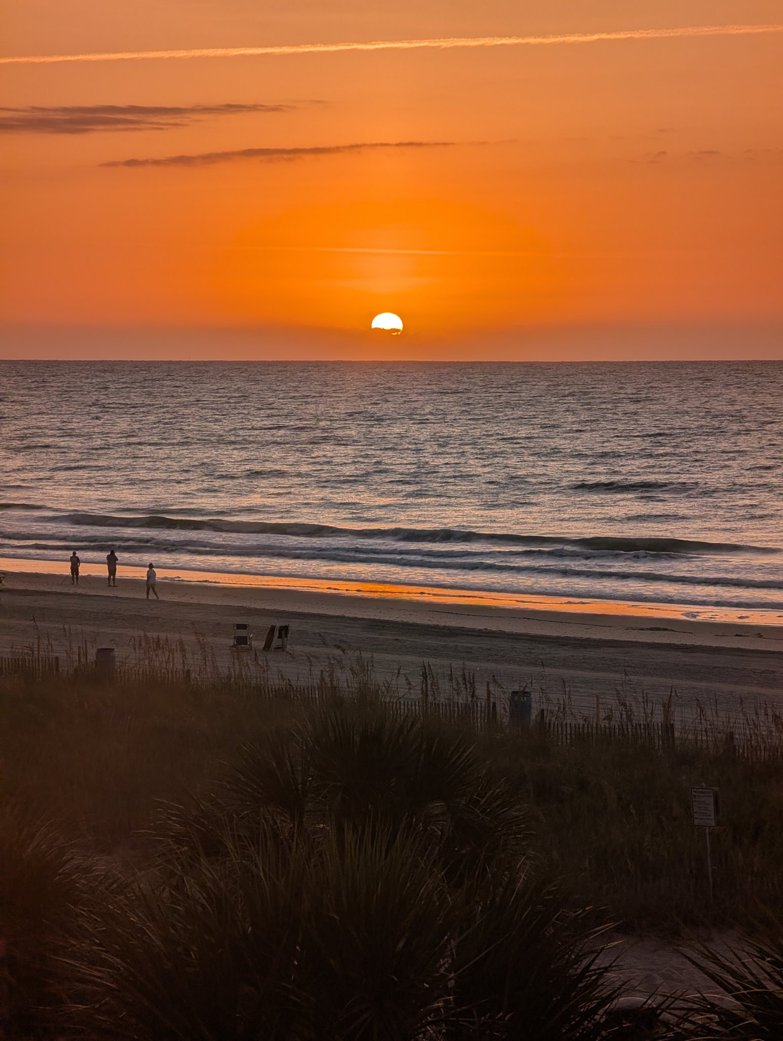 Beach walkers at sunrise